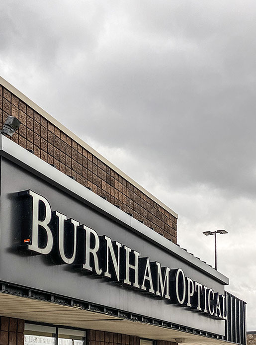 the storefront sign for burnham optical is shown in the bottom of frame